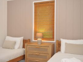 A bedroom with two beds and a lamp on a nightstand at 6 Hedgerows, Lanreath