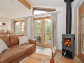 A living room with a fireplace and sofa at 2 Streamside in Lanreath