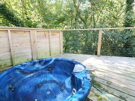 A hot tub on a wooden deck in an outdoor area at 2 Streamside Lanreath