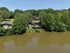 An outdoor area with cabins near a lake at 4 Water's Edge in Lanreath