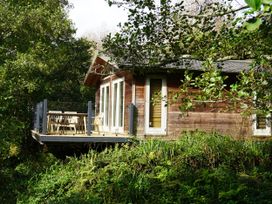 A cabin with a deck and outdoor seating at 4 Water's Edge in Lanreath
