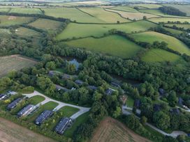 An aerial view of houses and fields at 6 Water's Edge in Lanreath