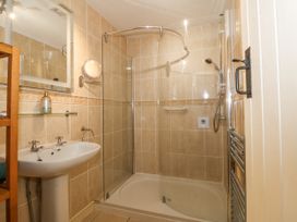 A bathroom with a shower enclosure a sink a mirror and a towel rack at Sea View apartment in Borth-Y-Gest