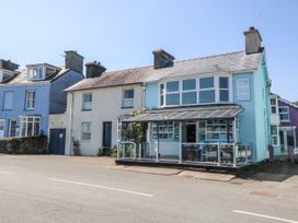 A row of houses with a blue take-away shop named Sea View apartment in Borth-Y-Gest
