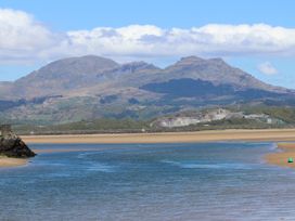 A river flowing past a sandy beach with mountains in the background at Sea View apartment in Borth-Y-Gest