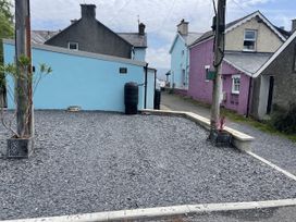 An outdoor area with a blue wall and a gray gravel surface at Sea View apartment Borth-Y-Gest