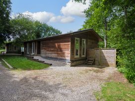 A wooden house with windows and a gravel path at 14 Stonerush Valley in Lanreath