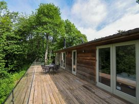 A wooden deck with a table and chairs at 14 Stonerush Valley in Lanreath