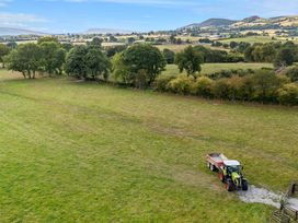 A tractor with a trailer in a grassy field at Meadow Retreat Nantmel near Rhayader