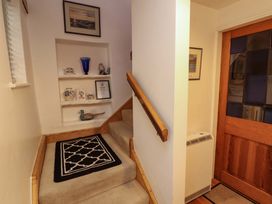 A staircase with a handrail in a hallway at Holemire Barn in Lorton