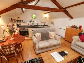 A living room with a kitchen area and dining table at Holemire Barn in Lorton