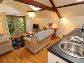 A living room with a sofa and dining area at Holemire Barn in Lorton