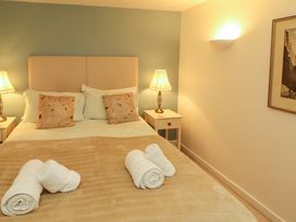 A bedroom featuring a bed with cushions and lamps at Holemire Barn in Lorton