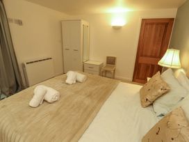 A bedroom with a bed and a chair at Holemire Barn Lorton