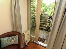 A room with a staircase outside and a chair at Holemire Barn Lorton
