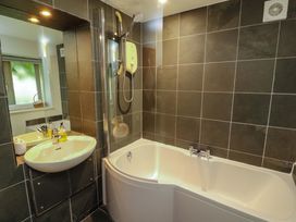 A bathroom with a bathtub and shower at Holemire Barn in Lorton