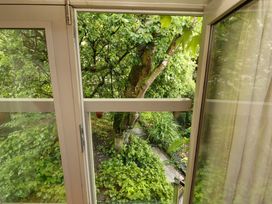 A view of a garden with trees and greenery at Holemire Barn Lorton