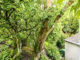 A garden with trees and a pathway at Holemire Barn in Lorton