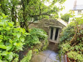 An outdoor view of a stone building surrounded by plants at Holemire Barn Lorton