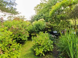 A garden with plants and a pathway at Holemire Barn in Lorton