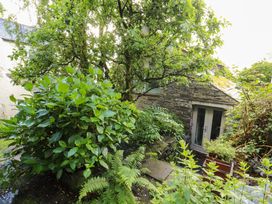 A garden with plants and a stone wall at Holemire Barn in Lorton