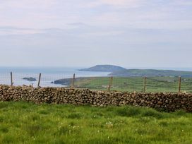 A view of a landscape with a stone wall and sea in the background at Dalar Deg Aberdaron