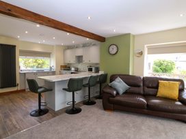 A kitchen with bar stools and a sofa at Dalar Deg in Aberdaron