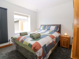 A bedroom with a bed and nightstand at Dalar Deg Aberdaron