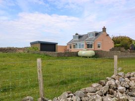 A house with a garage and lawn at Dalar Deg Aberdaron