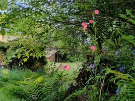 A garden with flowers and a shed at The Patio Flat in Bodmin Moor