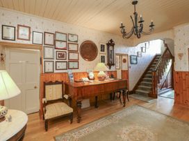 A hallway with a desk, chair, and staircase at Cairbre House in Dungarvan, County Waterford