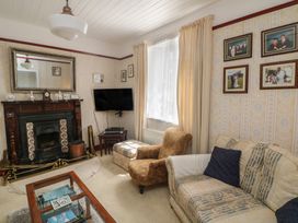 A living room with a fireplace and television at Cairbre House Dungarvan, County Waterford