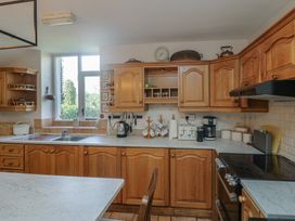A kitchen with wooden cabinets and appliances at Cairbre House in Dungarvan, County Waterford