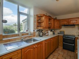 A kitchen with wooden cupboards and a window at Cairbre House in Dungarvan, County Waterford