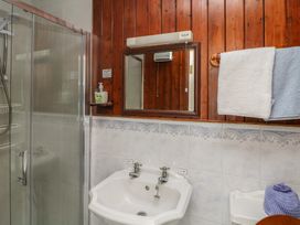 A bathroom with a shower, mirror, sink and towels at Cairbre House in Dungarvan, County Waterford