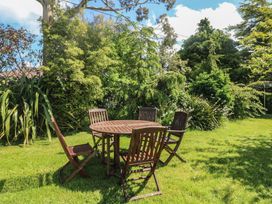 A garden with a wooden table and chairs at Cairbre House in Dungarvan, County Waterford