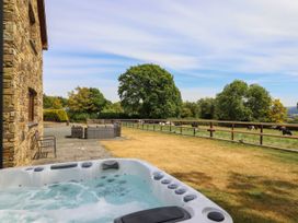 An outdoor area with a hot tub and seating at Ty Berllan in Caersws