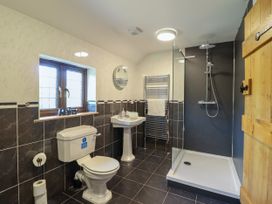 A bathroom with a shower, toilet, and sink at Ty Berllan in Caersws