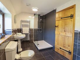 A bathroom featuring a sink, toilet, shower, and towel rail at Ty Berllan in Caersws