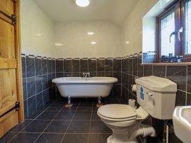 A bathroom with a bathtub and toilet at Ty Berllan in Caersws