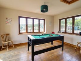 A game room with a billiard table and chairs at Ty Berllan in Caersws