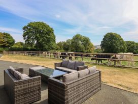 A seating area with a table and cows grazing at Ty Berllan in Caersws