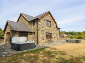 An outdoor area with a hot tub and seating at Ty Berllan in Caersws