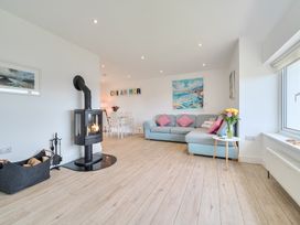 A living room with a fireplace and seating at Chi An Mor in Porth