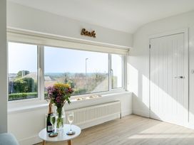A living room with a window and flowers at Chi An Mor in Porth