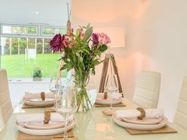 A dining room with a table set and flowers at Chi An Mor in Porth