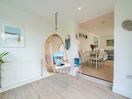 A living room with a hanging chair and dining area at Chi An Mor in Porth