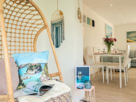 A dining room with a hanging chair and table set at Chi An Mor in Porth