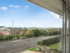 A view of houses and ocean from a window at Chi An Mor in Porth
