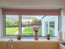 A kitchen window with a flower vase and sink at Chi An Mor in Porth